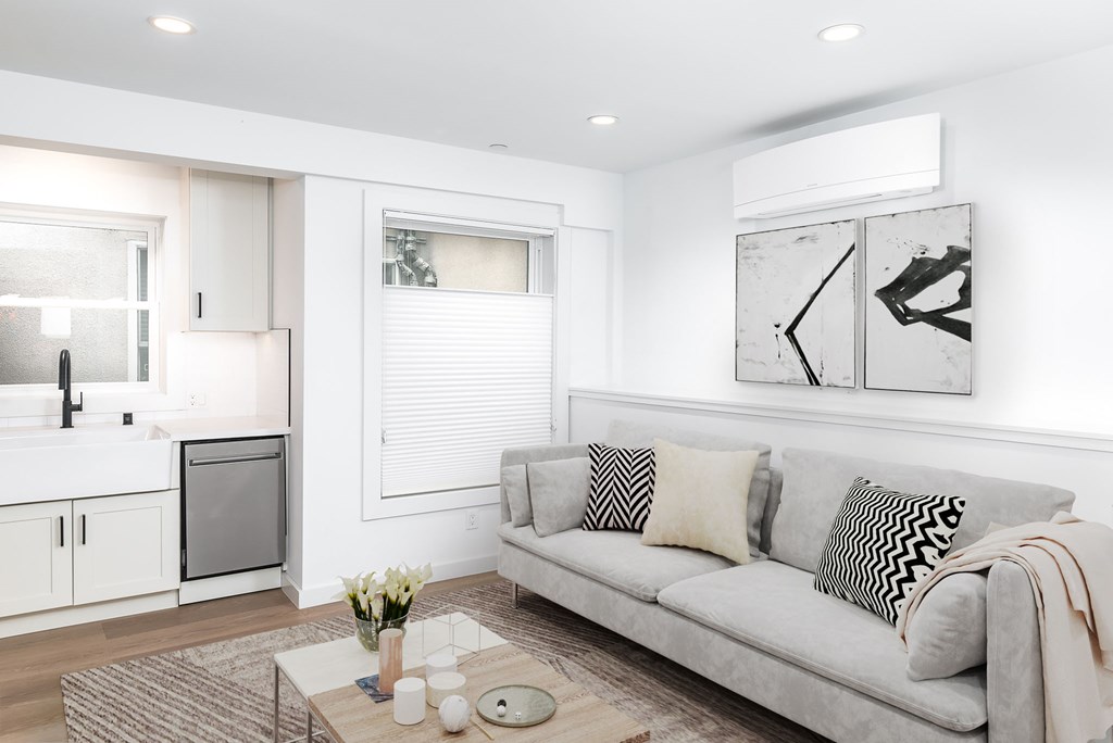 A modern living room with a grey sofa and a coffee table.