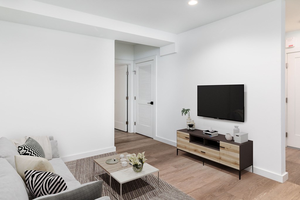 A living room with a grey couch and a white coffee table.