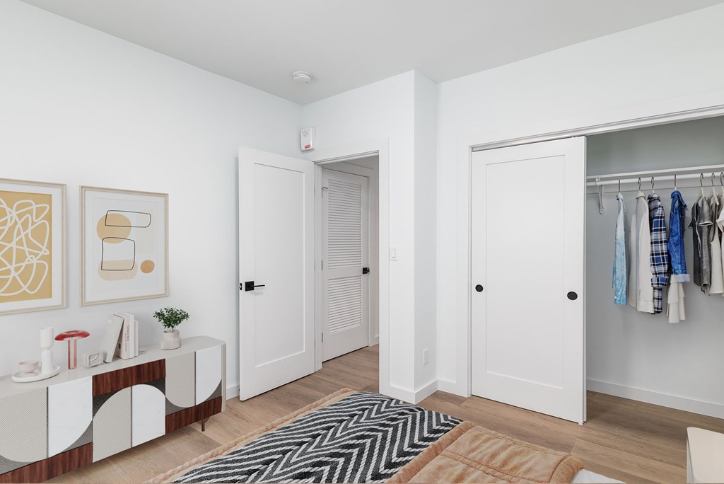 A white hallway with a black and white rug on the floor.