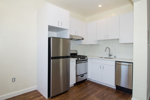 A kitchen with white cabinets and stainless steel appliances.