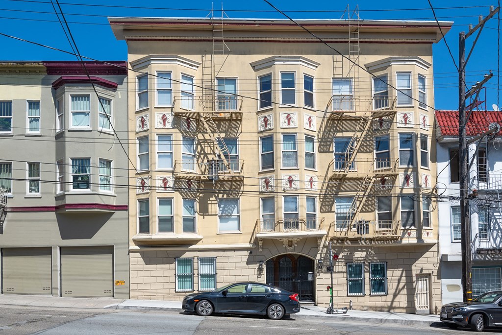 A large tan building with a fire escape on the side.