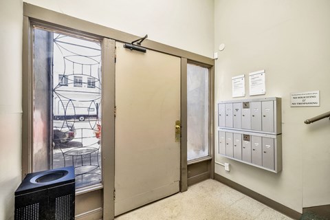 A room with a door, a wall-mounted mailbox, and a sign that says "NO SHORT-TERM PARKING".