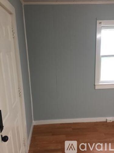 A room with a white door and a window.