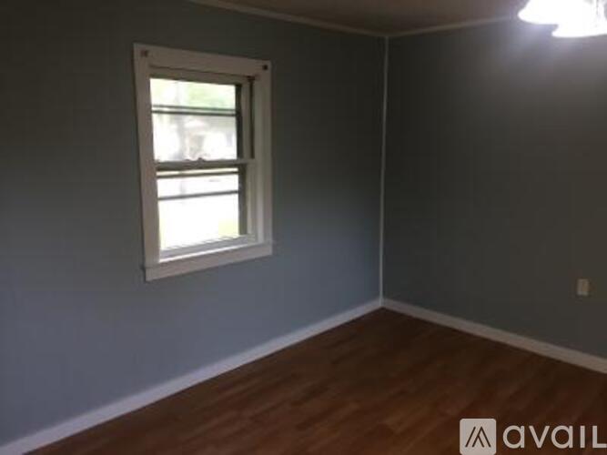 A room with a window and wooden floors.