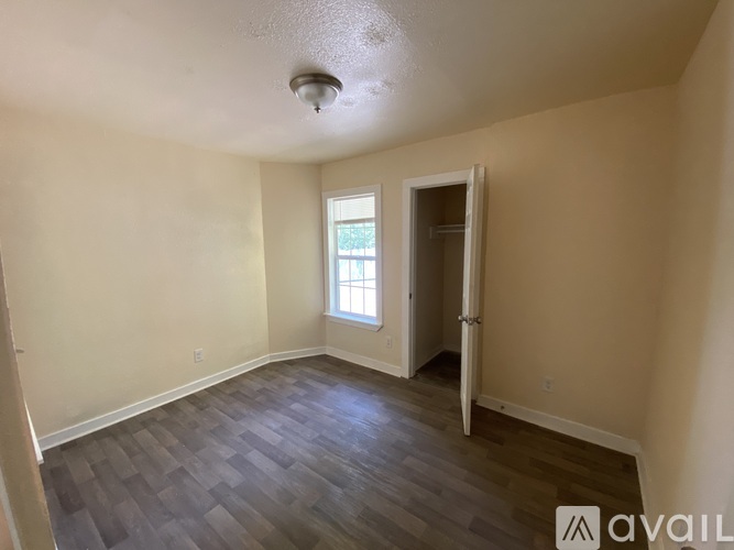 A room with a window and a door is available for rent.