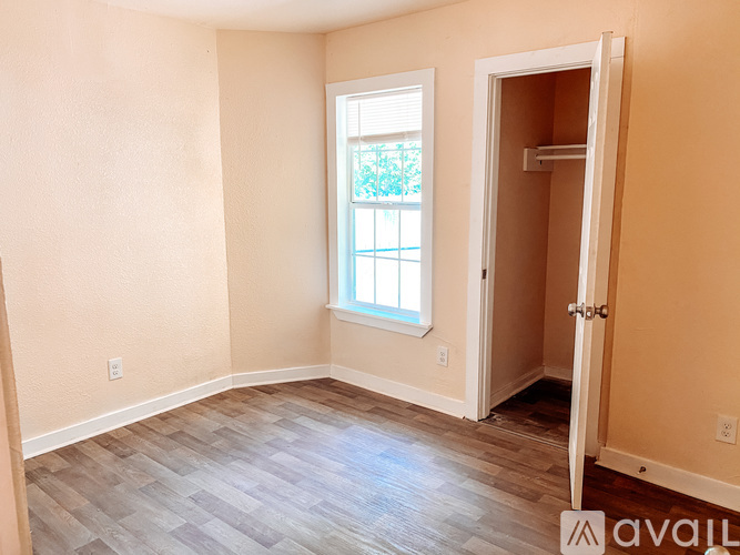 A room with a window and a door is available for rent.