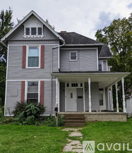 A two-story house with a front porch and a small front yard.