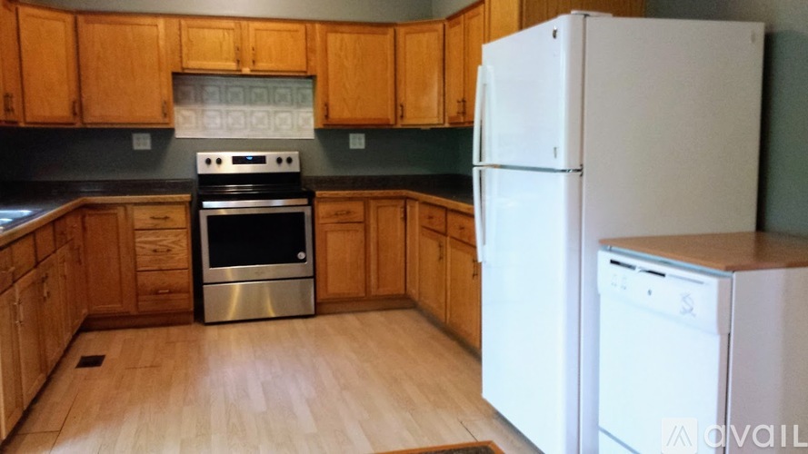 A kitchen with wooden cabinets and a white refrigerator.