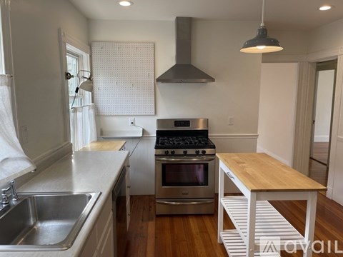 A modern kitchen with a stainless steel oven and wooden island.