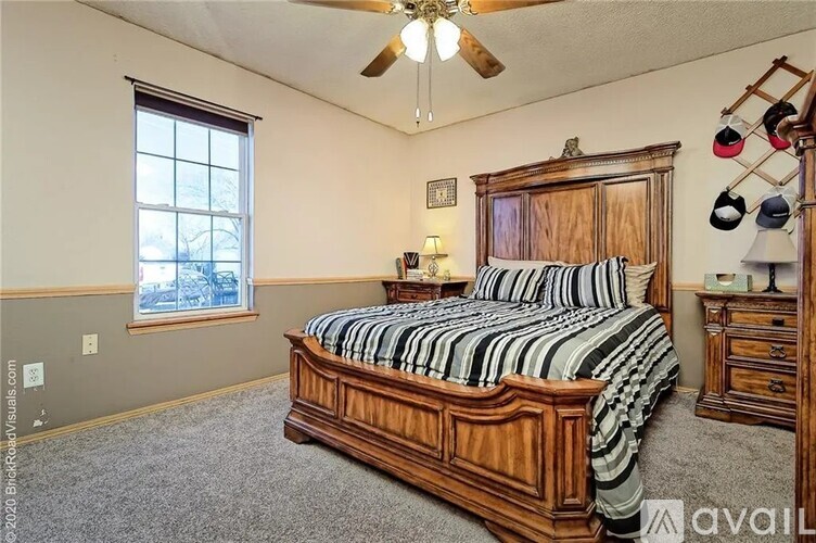 A bedroom with a large bed and a ceiling fan.