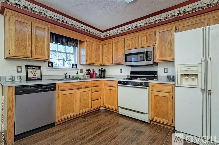 A kitchen with wooden cabinets and white appliances.