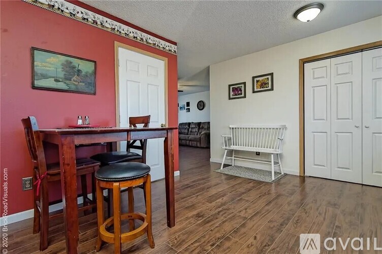 A dining room with a wooden table and chairs.