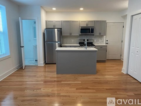 A kitchen with wooden floors and a refrigerator.