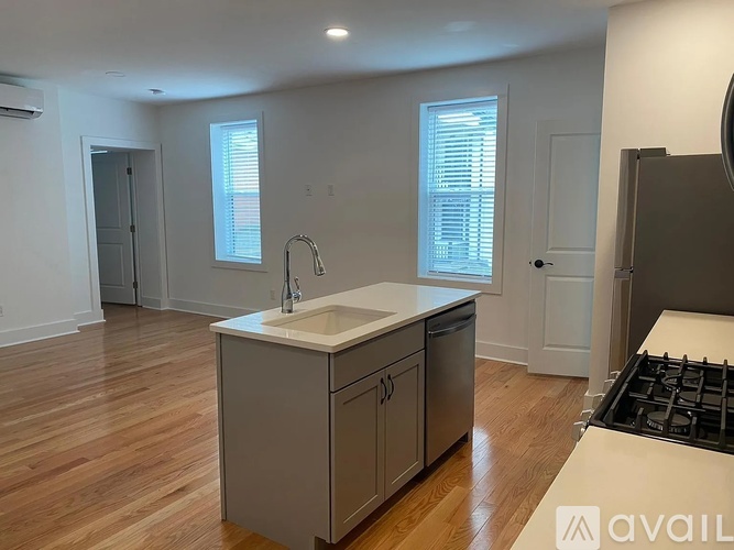 A kitchen with a sink, stove, and cabinets.