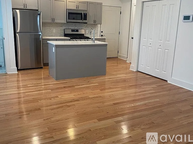 A kitchen with a wooden floor and white walls.