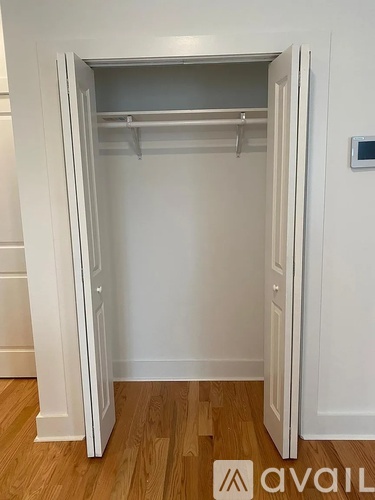 A white closet with a shelf and a hanger.