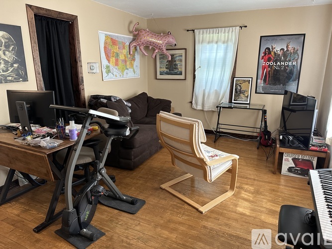 A living room with a couch, chair, and exercise bike.