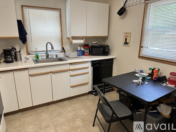 A kitchen with white cabinets and a black table.