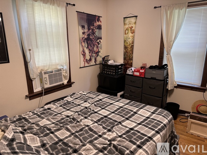 A bedroom with a bed, dresser, and window with curtains.