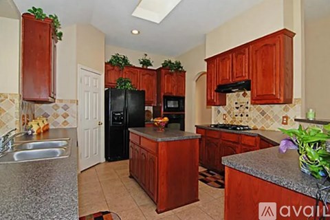 A kitchen with wooden cabinets and a black fridge.