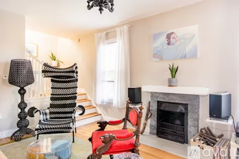 A living room with a fireplace and a painting on the wall.