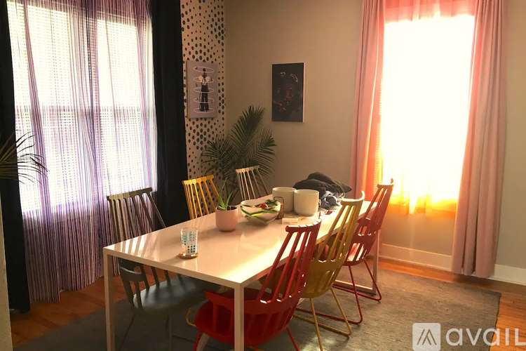 A dining room with a table and chairs.