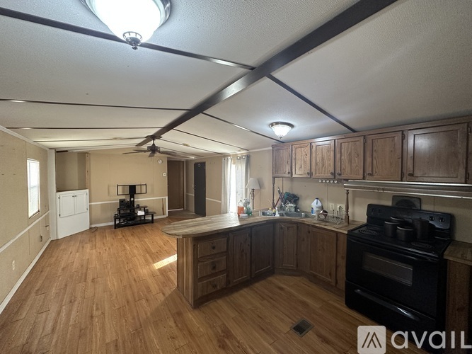 A kitchen with wooden floors and a black stove top oven.