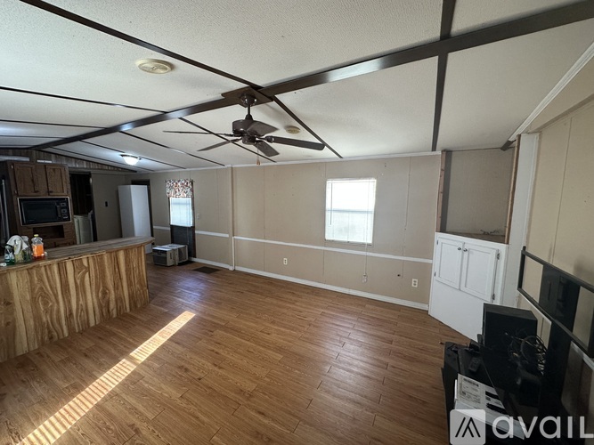 A room with wooden floors and a ceiling fan.