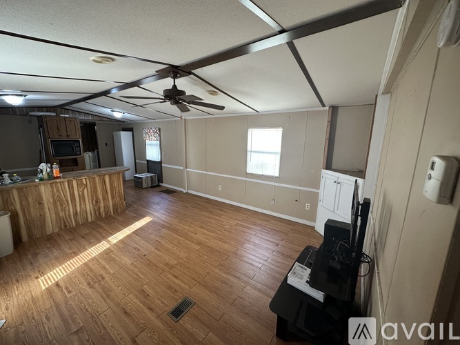 A room with wooden flooring and a ceiling fan.