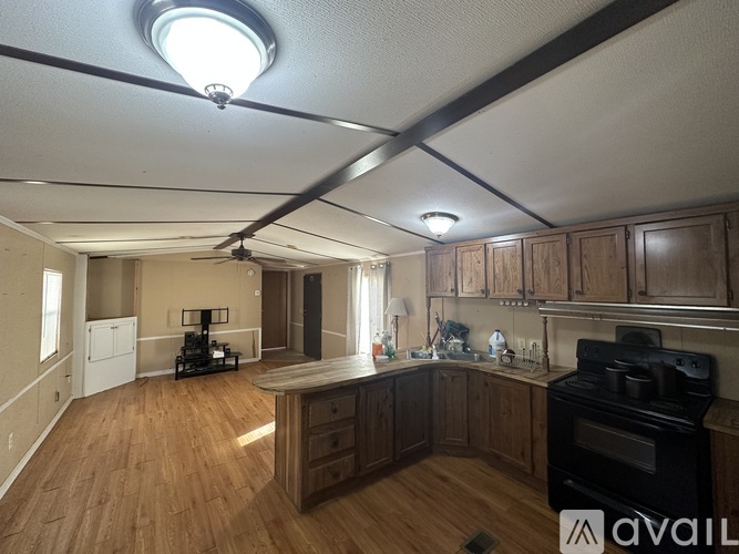 A kitchen with wooden floors and a black stove top oven.