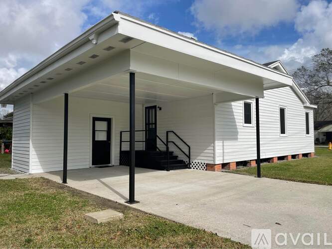 A small white building with a black door and windows is available for purchase.