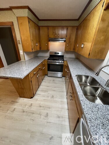 A kitchen with wooden cabinets and a granite countertop.