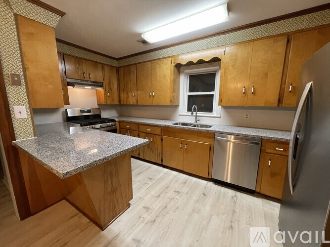 A kitchen with wooden cabinets and a granite countertop.