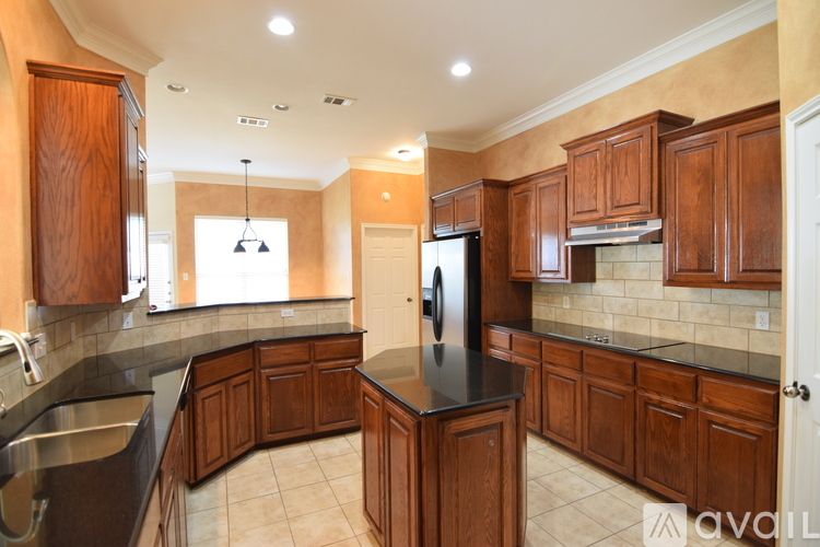 A kitchen with wooden cabinets and a black countertop.
