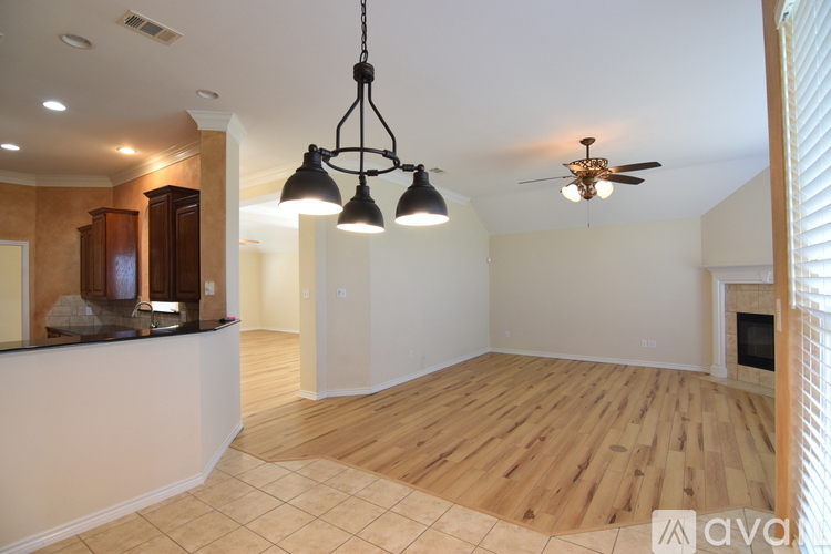 A living room with a wooden floor and a ceiling fan.