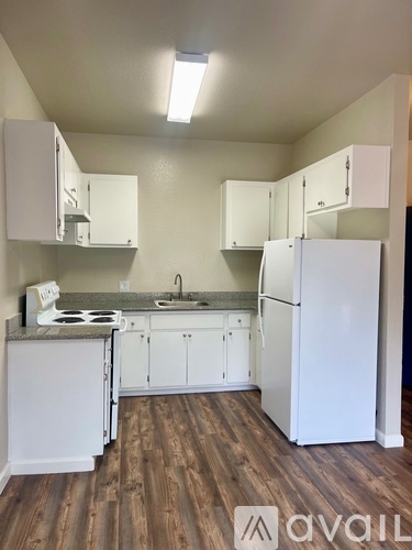 A kitchen with white appliances and cabinets.