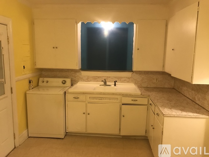 A bathroom with a sink, mirror, and cabinets.