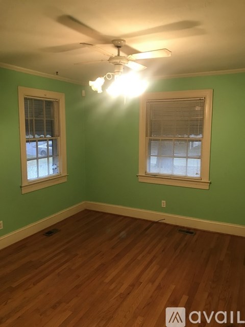 A room with green walls and wood flooring.