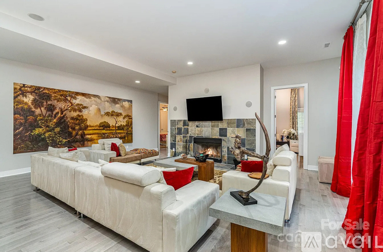 A living room with a large painting on the wall and a fireplace.