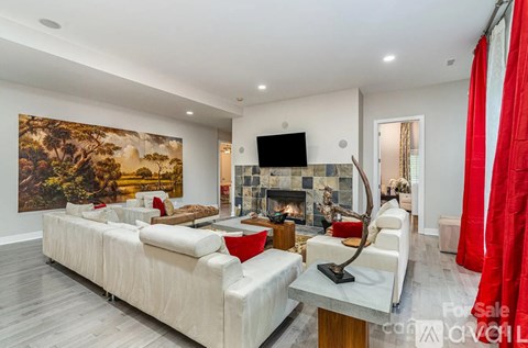 A living room with a large painting on the wall and a fireplace.