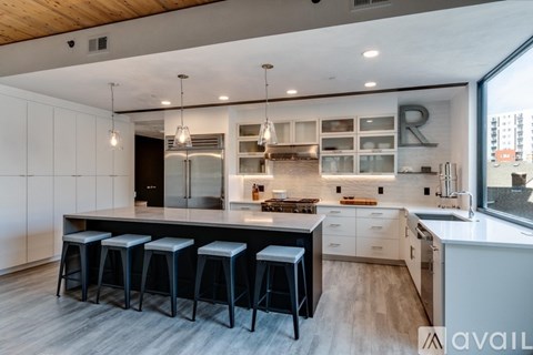 A modern kitchen with a bar area and a view of the city.