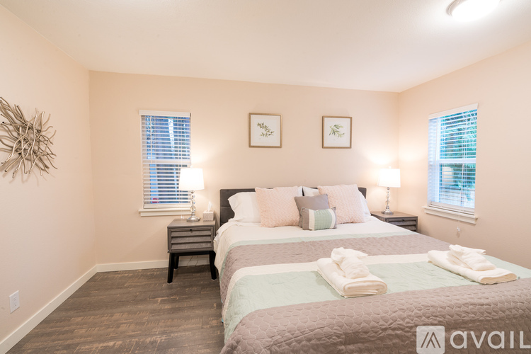 A bedroom with two beds and two lamps.