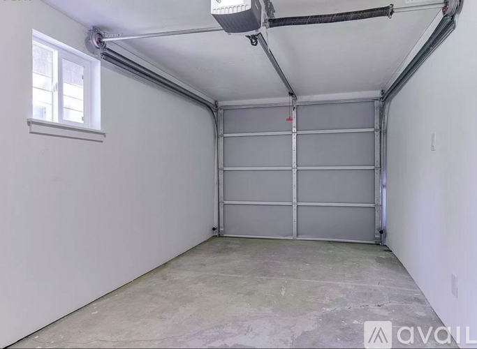 A spacious garage with a grey floor and white walls.