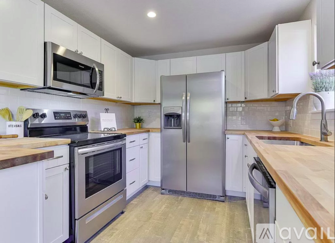 A kitchen with white cabinets and stainless steel appliances.