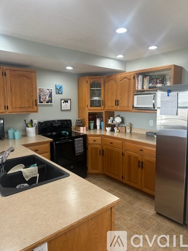 A kitchen with wooden cabinets and a black stove top oven.
