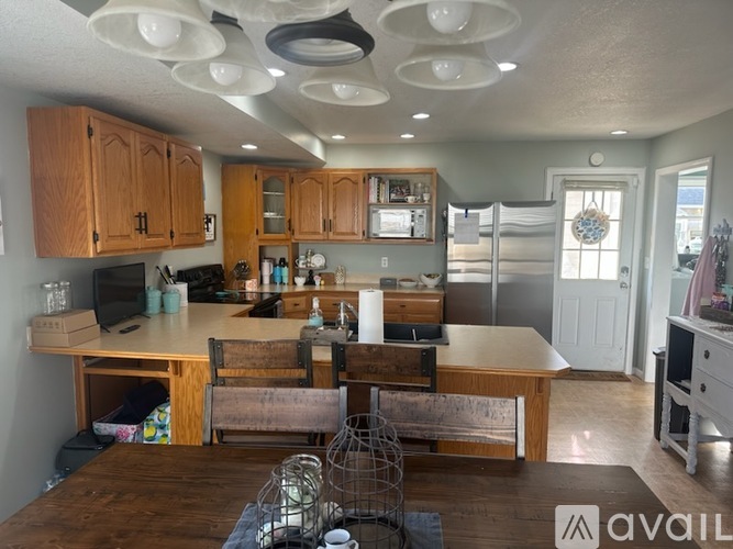 A kitchen with wooden cabinets and a dining table.