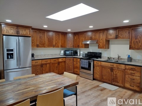 A kitchen with wooden cabinets and a wooden table.