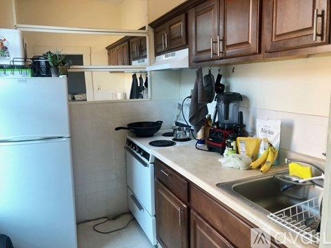 A kitchen with a white refrigerator and wooden cabinets.