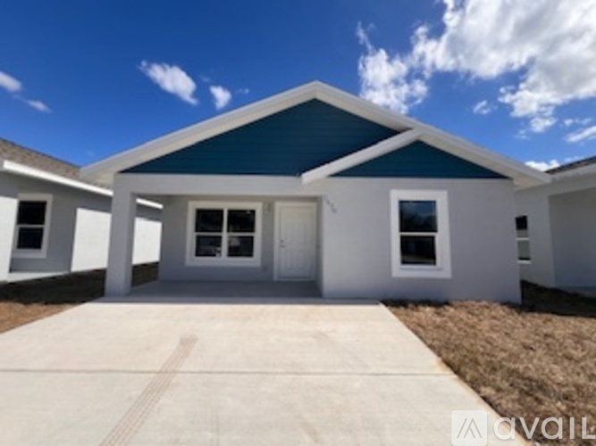 A house with a white front and a blue roof is for sale.