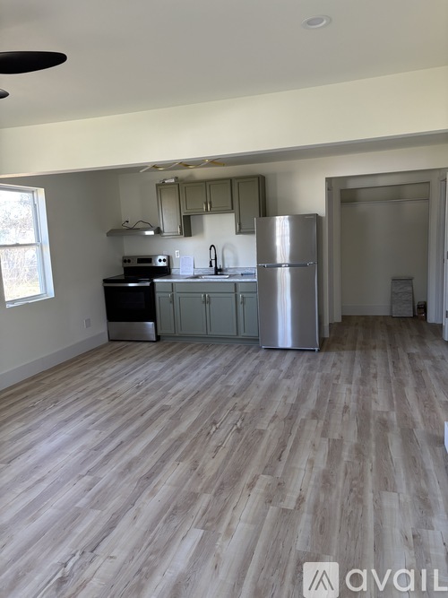 A kitchen with a refrigerator, stove, and sink.
